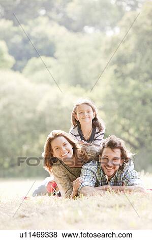 Stock Photo - Family lying on blanket in countryside. Fotosearch