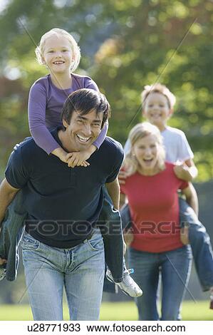 Family piggy-backs in the park View Large Photo Image Stock Image - Family piggy-backs in the park. Fotosearch