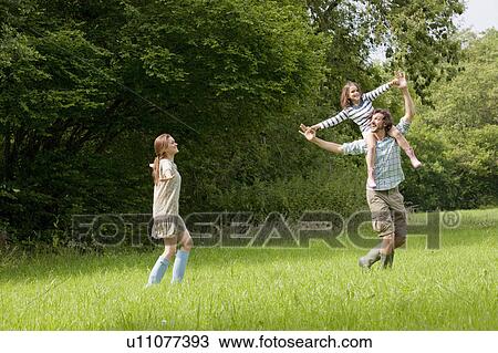 Stock Image - Family running in country field. Fotosearch