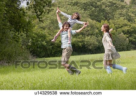 Stock Photo - Family running in country field. Fotosearch