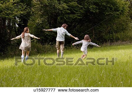 Family running in country field View Large Photo Image Stock Photo - Family running in country field. Fotosearch