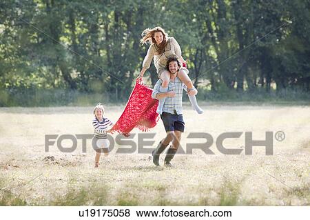 Family running in country field View Large Photo Image Stock Photo - Family running in country field. Fotosearch