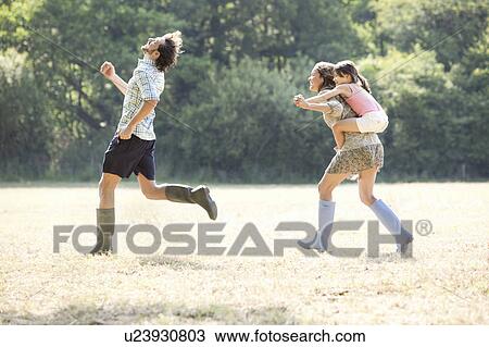 Family running together in country field View Large Photo Image Stock Image - Family running together in country field. Fotosearch