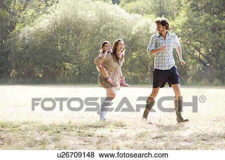 Stock Photo - Family running together in country field. Fotosearch