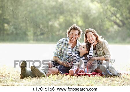 Family sitting on blanket in countryside View Large Photo Image Stock Photograph - Family sitting on blanket in countryside. Fotosearch