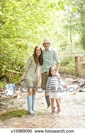 Stock Photography - Family standing in country stream. Fotosearch