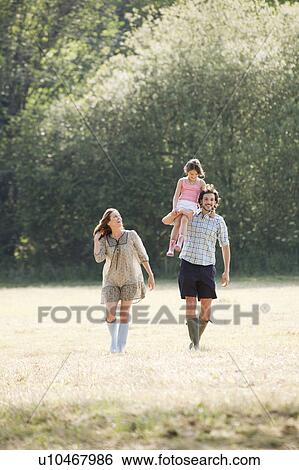 Family walking through country field View Large Photo Image Stock Photograph - Family walking through country field. Fotosearch