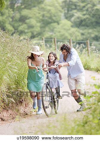 Family with daughter on bicycle View Large Photo Image Stock Image - Family with daughter on bicycle. Fotosearch