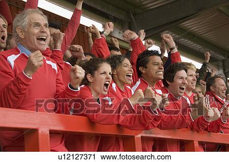 Stock Image - Fans celebrating at football match. Fotosearch