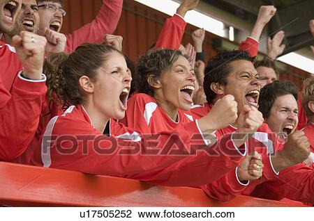 Stock Image - Fans celebrating at football match. Fotosearch