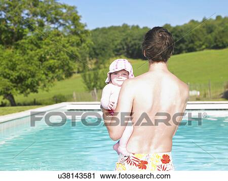 Stock Image - father and baby in pool. Fotosearch