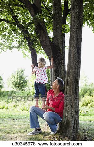 Father and Daughter Climbing on Tree View Large Photo Image Stock Photo - Father and Daughter Climbing on Tree. Fotosearch