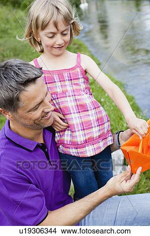 Picture - Father and Daughter With Paper Boat. Fotosearch