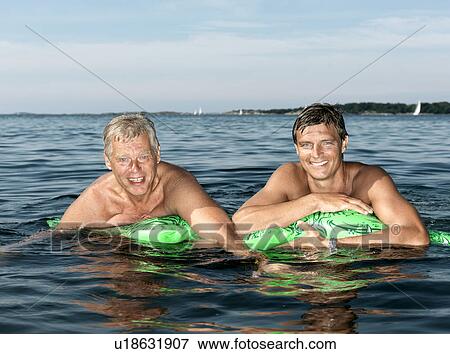 Stock Photo - Father and son on inflatable crocodile. Fotosearch