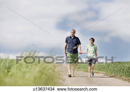 Picture - Father and son walking down a road. Fotosearch
