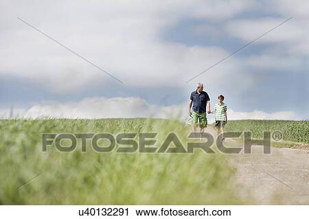 Father and son walking down a road View Large Photo Image Stock Image - Father and son walking down a road. Fotosearch