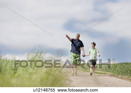 Stock Photography - Father and son walking down a road. Fotosearch