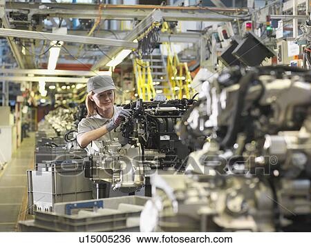 Stock Photograph - Female Car Worker And Car Parts. Fotosearch