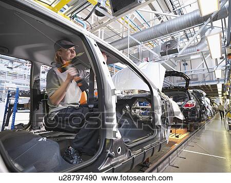 Stock Image - Female Car Worker On Production Line. Fotosearch
