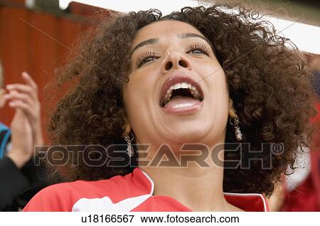 Stock Photo - Female fan singing at football match. Fotosearch