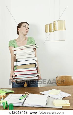 Stock Photo - Female student carrying stack of books. Fotosearch