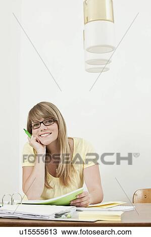 Stock Image - Female student sitting at table. Fotosearch