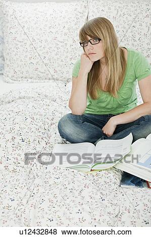 Female student sitting in bed, learning View Large Photo Image Stock Photo - Female student sitting in bed, learning. Fotosearch