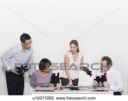 Four business people doing a jigsaw View Large Photo Image Stock Image - Four business people doing a jigsaw. Fotosearch