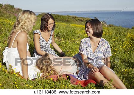 Stock Photograph - four girls in a field by the sea. Fotosearch