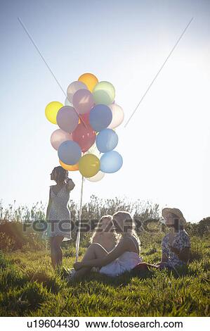 four girls in a field with balloons View Large Photo Image Stock Image - four girls in a field with balloons. Fotosearch