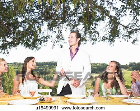 Stock Image - friends having dinner outside. Fotosearch