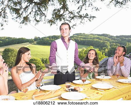 Stock Image - friends having dinner outside. Fotosearch