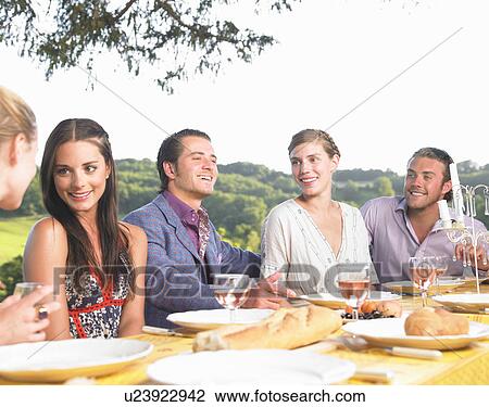 Stock Image - friends having dinner outside. Fotosearch