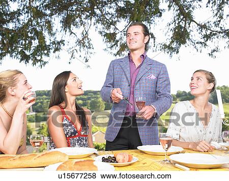 Stock Photo - friends having dinner outside. Fotosearch