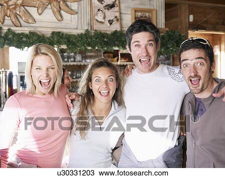 Stock Image - friends laughing in ski bar. Fotosearch