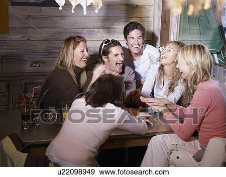 Stock Photo - friends laughing in ski lodge bar. Fotosearch
