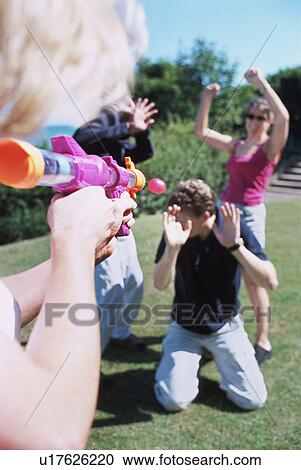 Friends playing with a water gun View Large Photo Image Stock Image - Friends playing with a water gun. Fotosearch