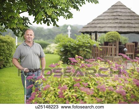 Stock Image - Gardener With Spade In Garden. Fotosearch