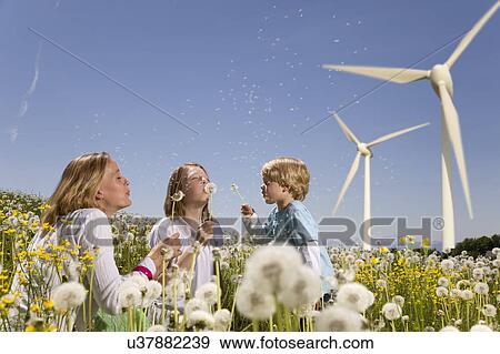Stock Photo - Girl and boy and mother at wind turbines. Fotosearch