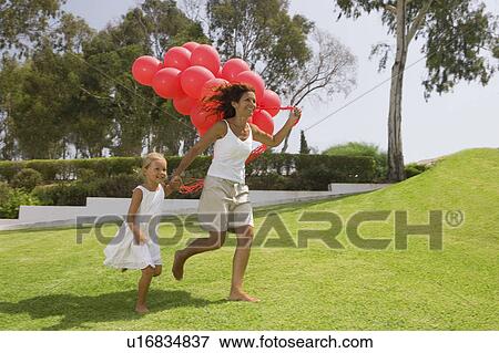Stock Photo - Girl and mother running with balloons. Fotosearch