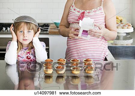 Girl baking with sieve on her head View Large Photo Image Stock Image - Girl baking with sieve on her head. Fotosearch