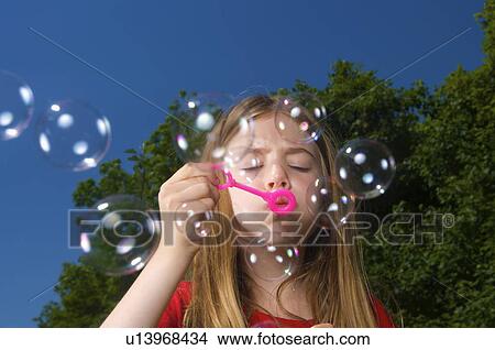 Girl blowing bubbles View Large Photo Image Picture - Girl blowing bubbles. Fotosearch