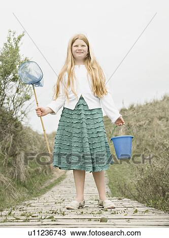 Stock Image - Girl holding fishing net & bucket. Fotosearch