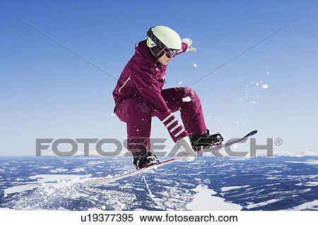 Girl in jumpsuit grabbing board mid-air. View Large Photo Image Stock Photography - Girl in jumpsuit grabbing board mid-air.. Fotosearch