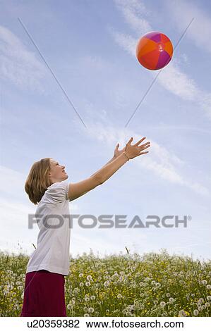 Girl in meadow playing ball View Large Photo Image Stock Image - Girl in meadow playing ball. Fotosearch
