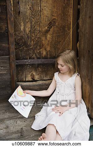 Stock Photo - Girl in white reading.. Fotosearch