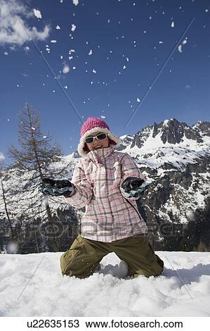 Girl kneeling down throwing snow. View Large Photo Image Stock Image - Girl kneeling down throwing snow.. Fotosearch