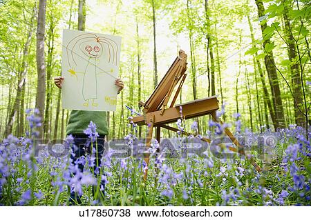 Stock Photo - Girl painting in the forest, fun drawing. Fotosearch