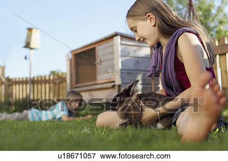 Girl playing with rabbit in garden View Large Photo Image Stock Photo - Girl playing with rabbit in garden. Fotosearch