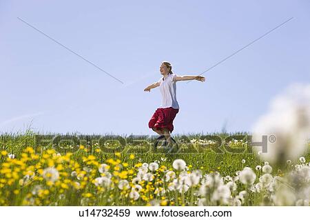 Stock Photo - Girl riding unicycle through meadow. Fotosearch